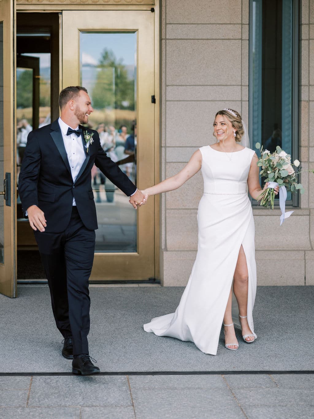 Couple walking hand in hand, both laughing, editorial wedding photography by Christopher Cook