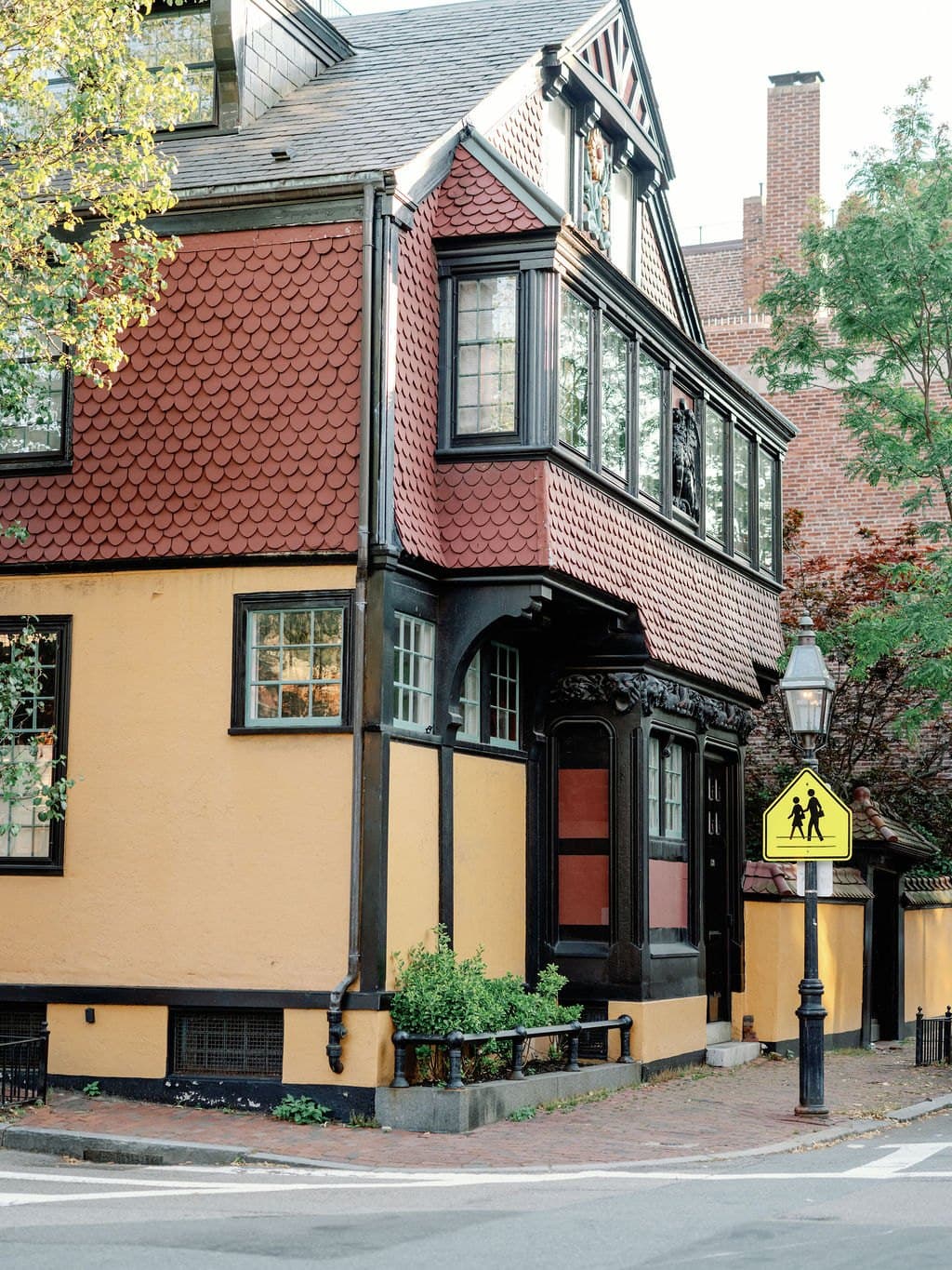 A shingled corner house and gas lamp on a Beacon Hill street in Boston
