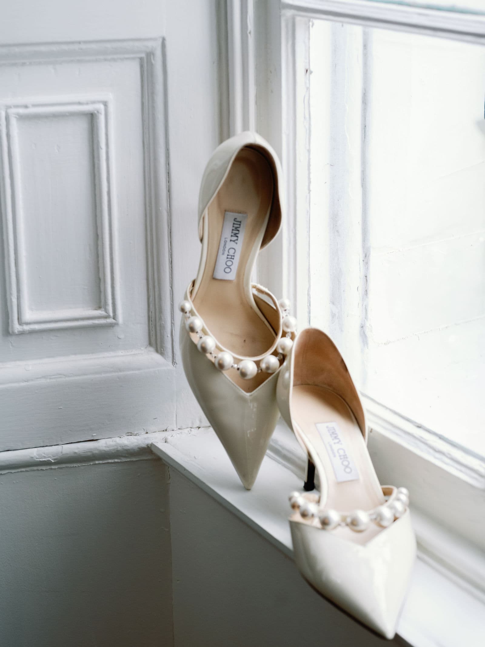 A pair of Jimmy Choo wedding shoes on a windowsill in Charleston