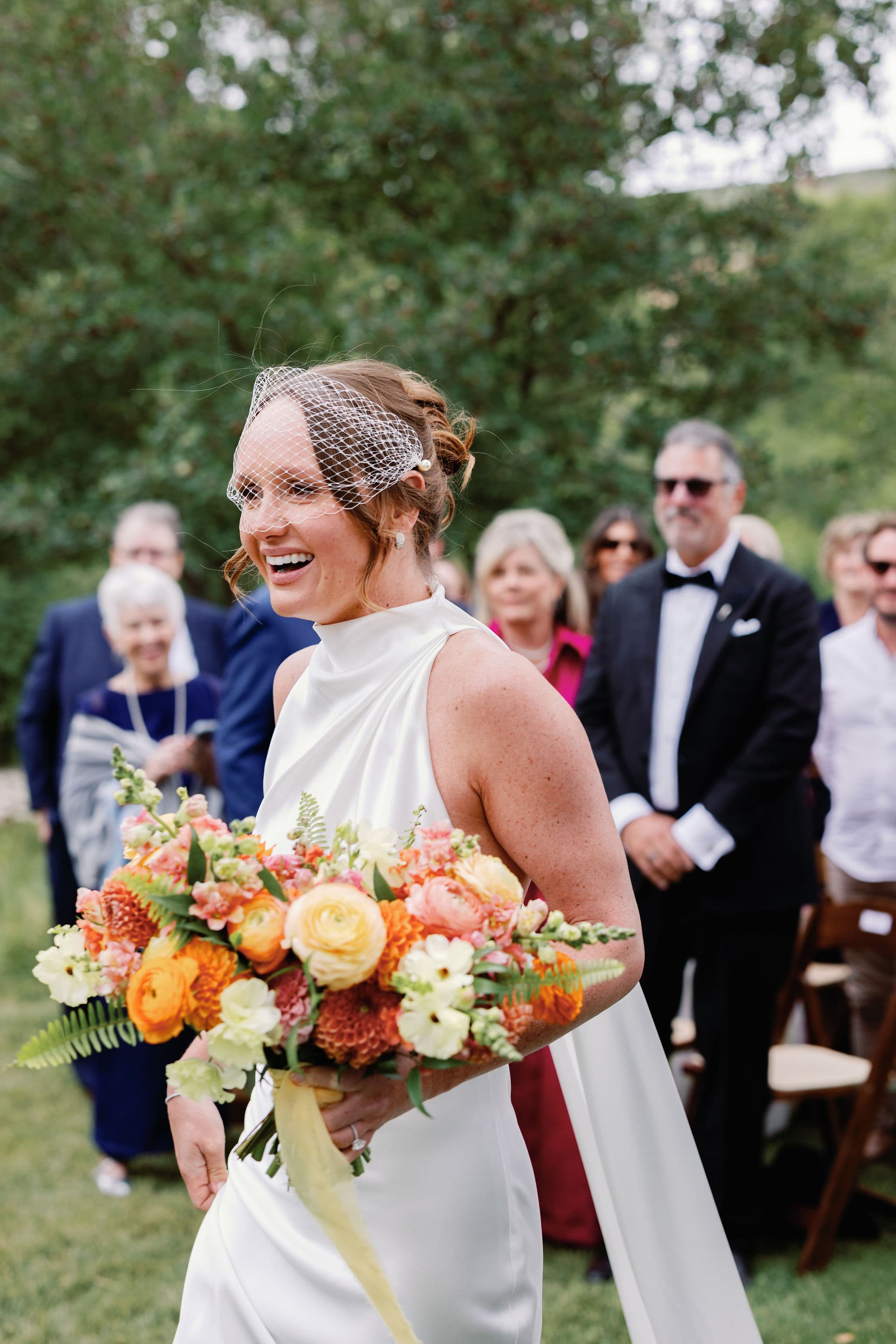 Breen laughing down the aisle in her birdcage veil at 4U Ranch, Park City