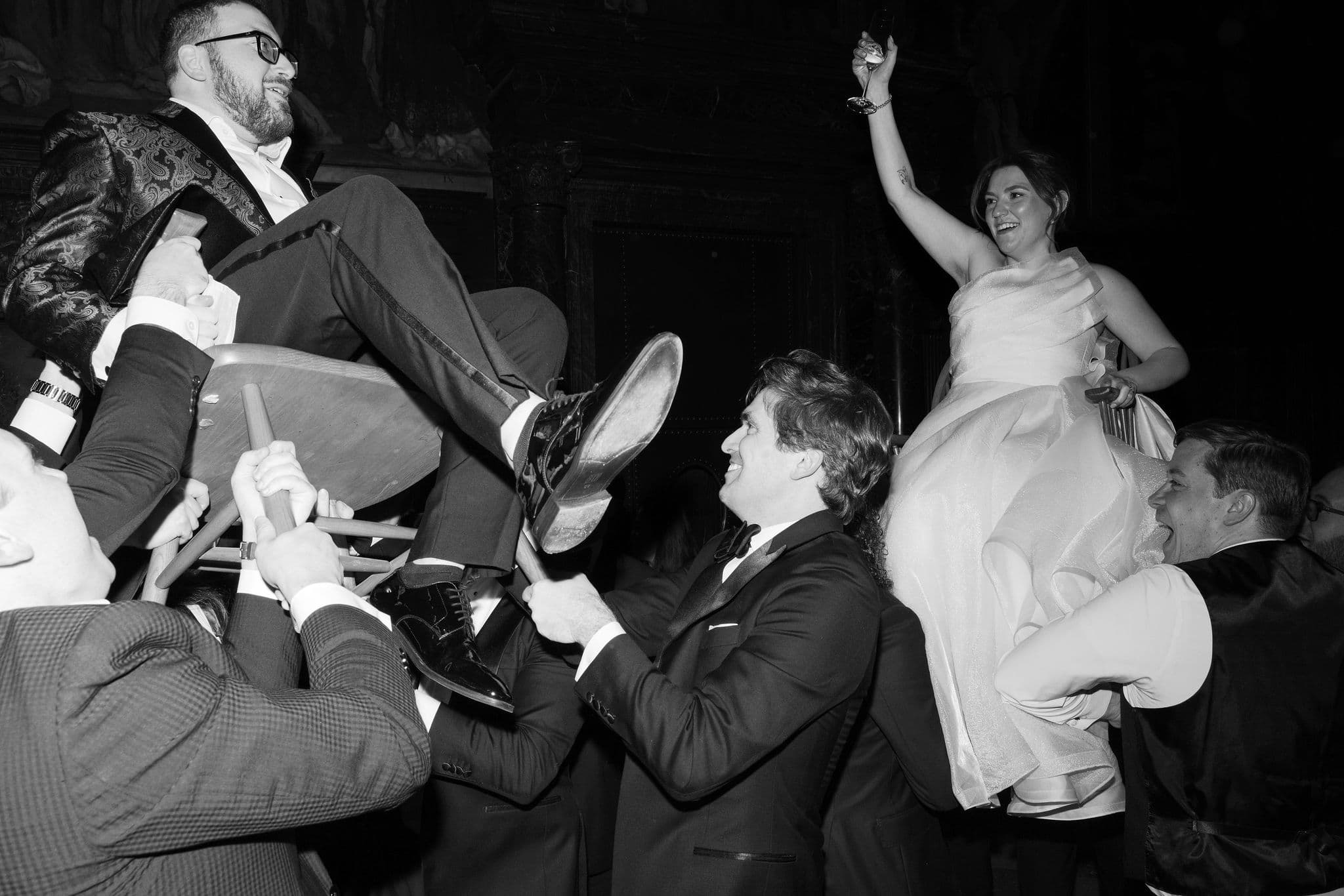A bride lifted on a chair during the hora at her wedding reception