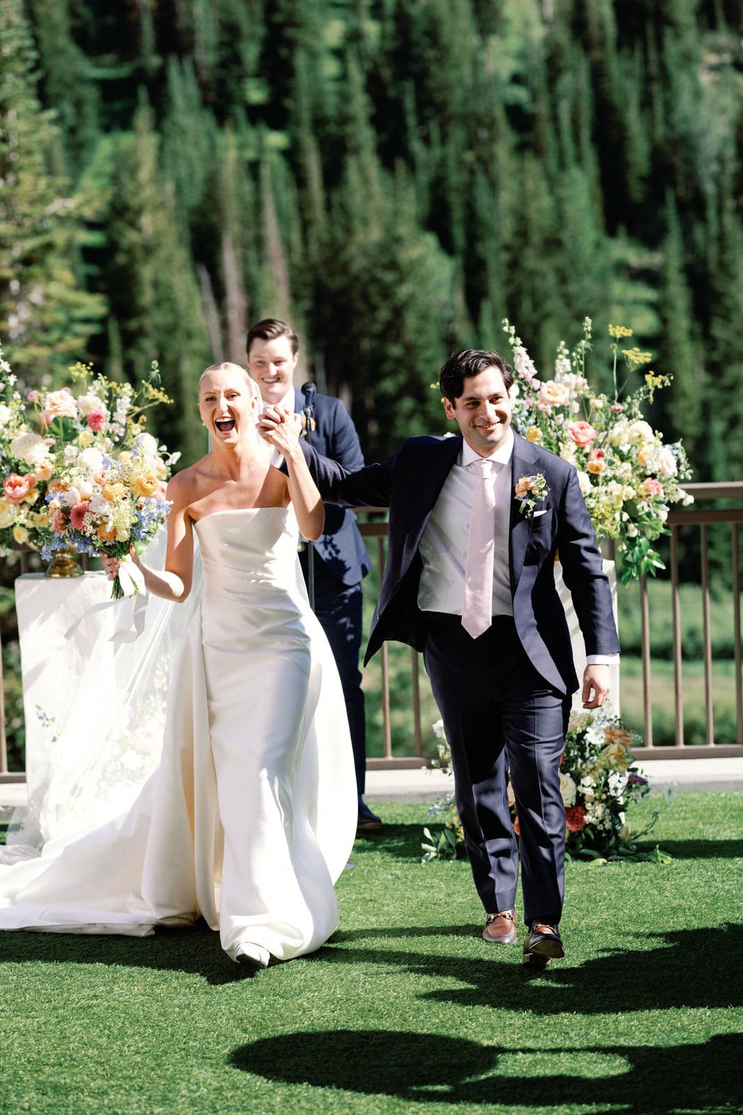Newly married couple laughing as they walk back down the aisle