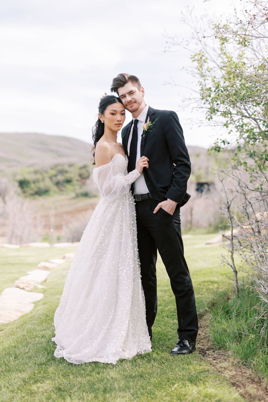Couple hand in hand through a wildflower meadow with the Wasatch behind them, Park City Utah wedding photography by Christopher Cook