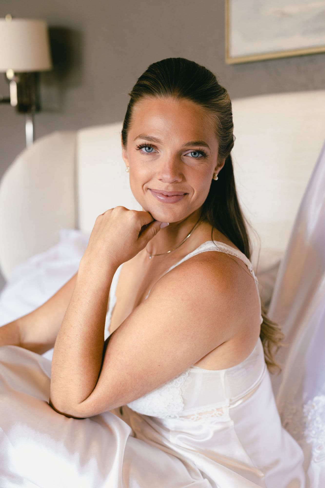 Marita in her wedding gown before the ceremony, chin resting on her hand