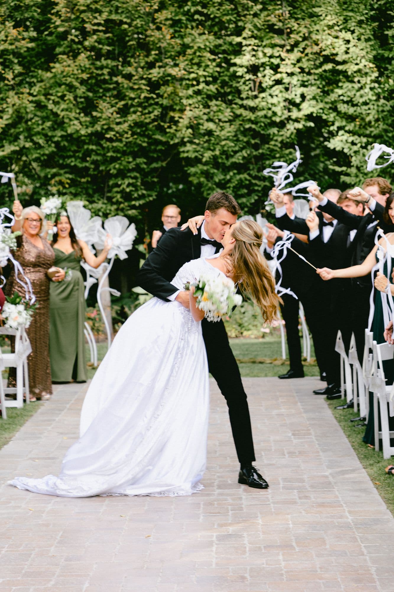 Kyle and Marita kissing on the way back up the aisle as their guests applaud