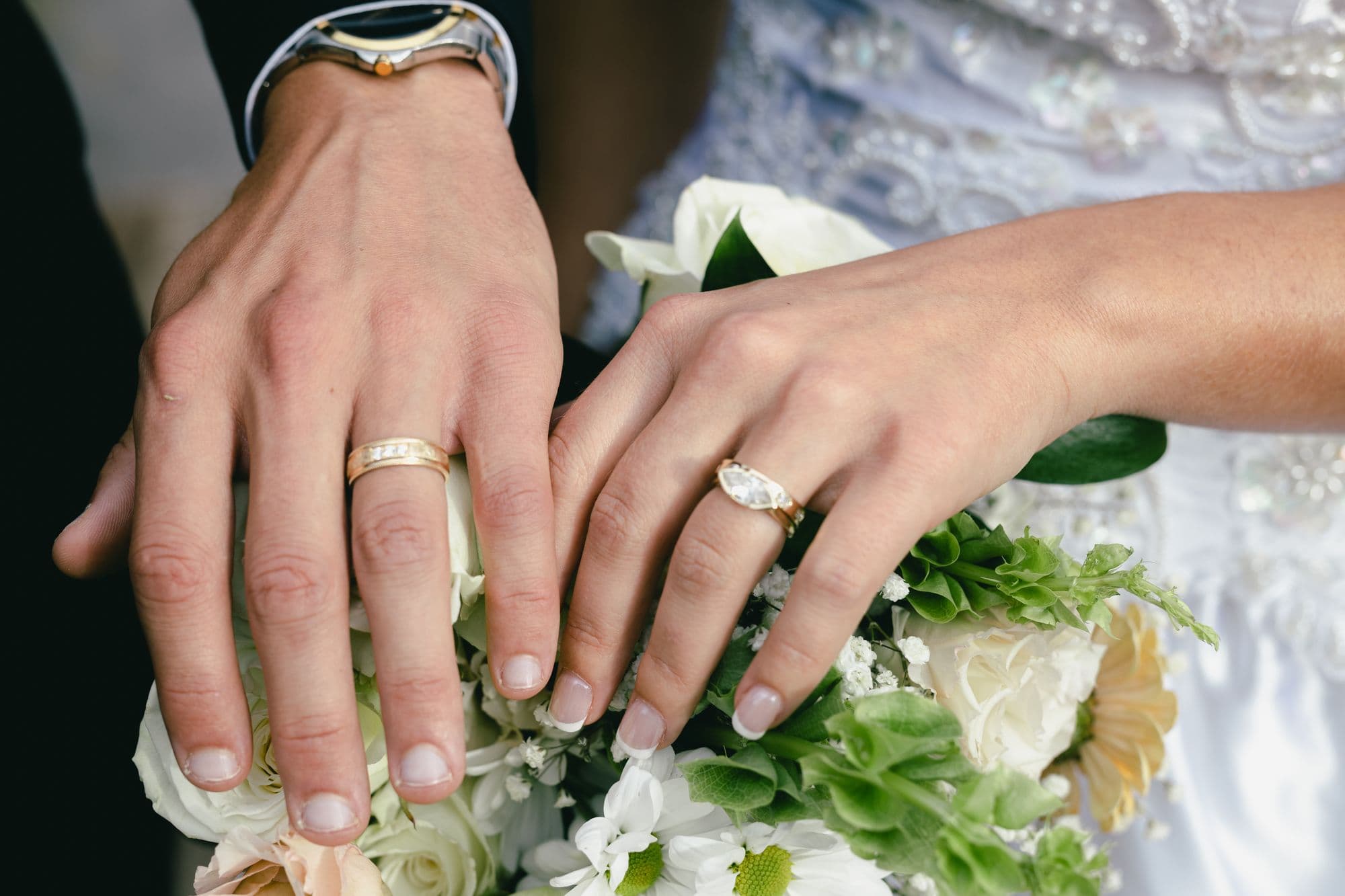 The couple’s hands together after the ceremony, both wedding bands on