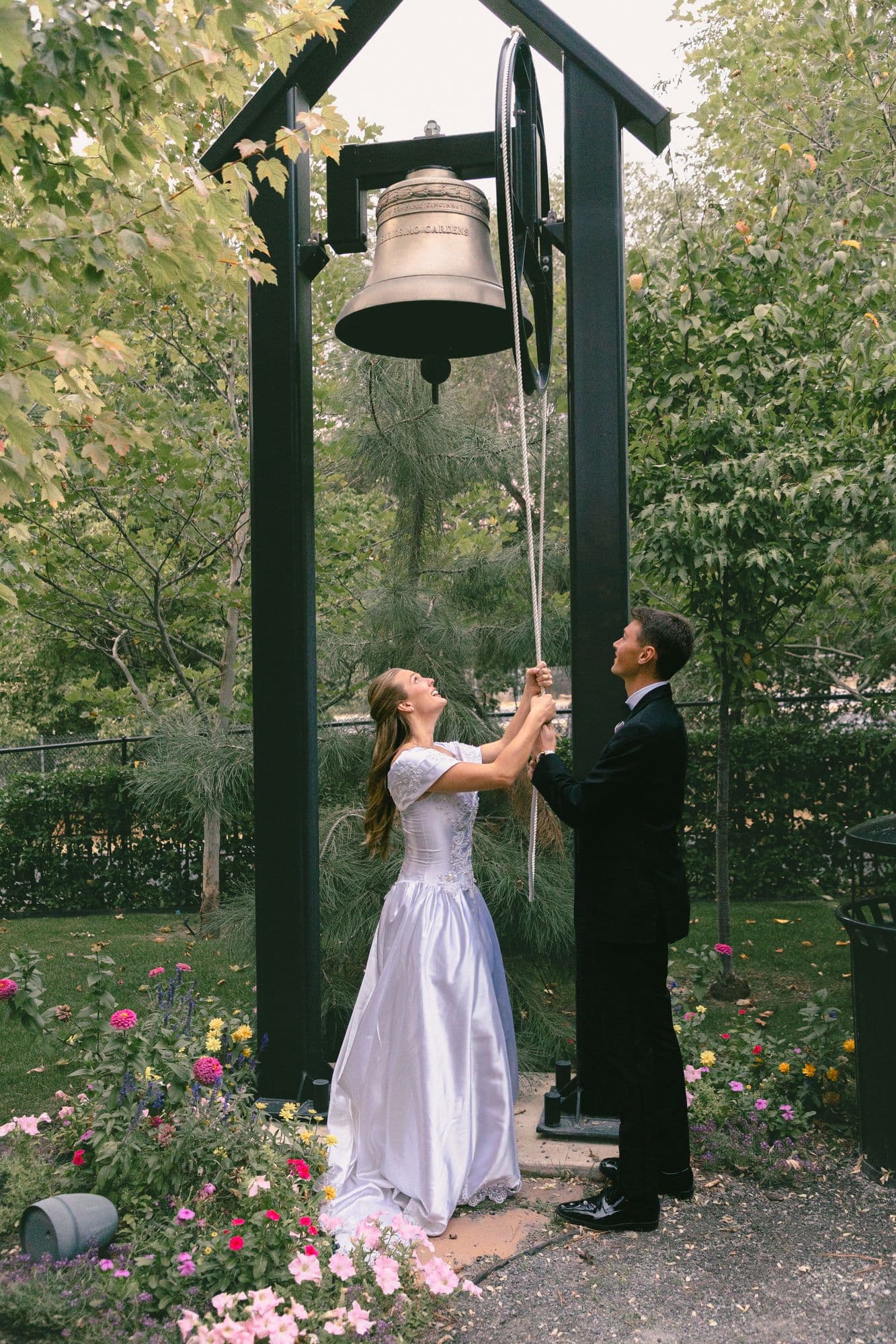 Marita ringing the garden bell after the ceremony while Kyle watches