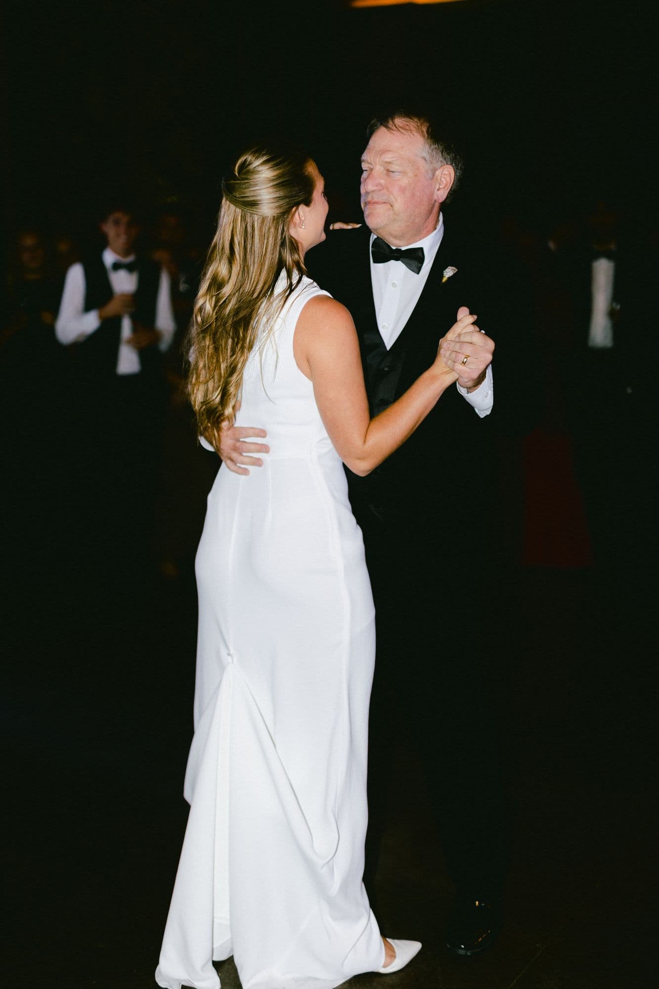 Marita dancing with her father at the reception in her second dress, a sleek one-shoulder gown