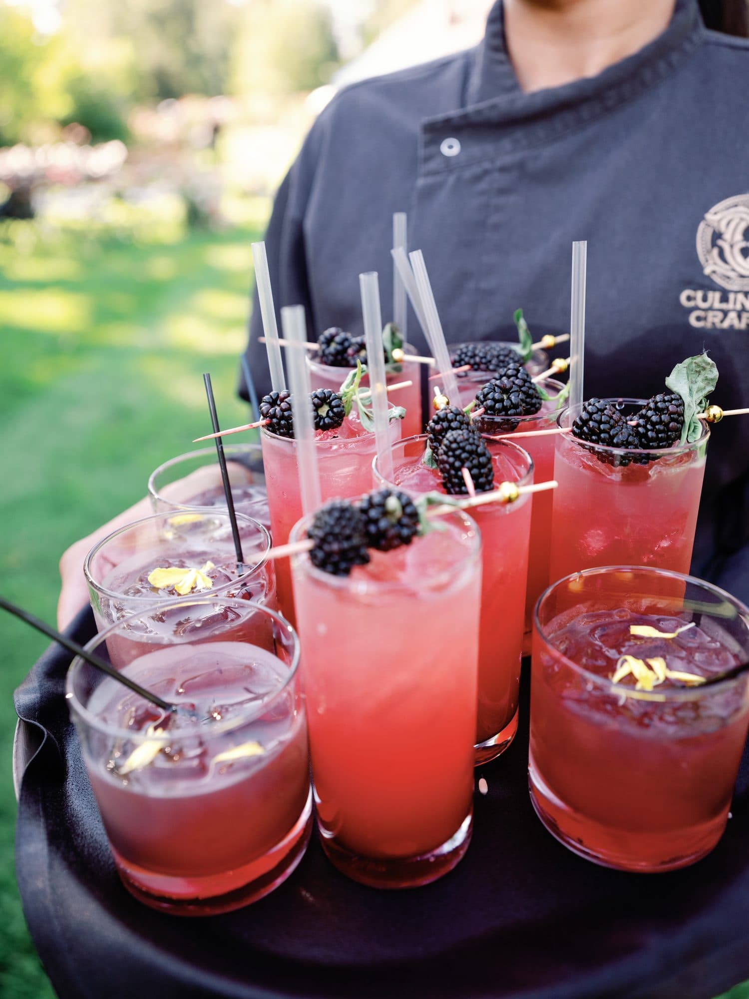 A tray of blackberry cocktails carried through cocktail hour