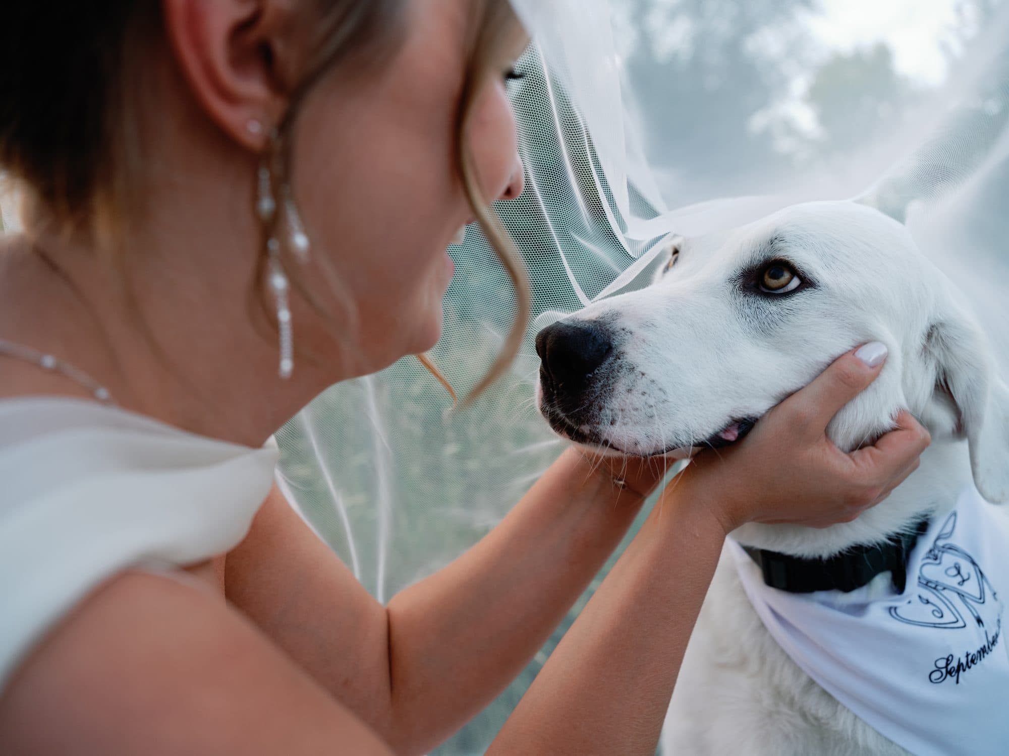 Lauren holding the white dog’s face close to hers