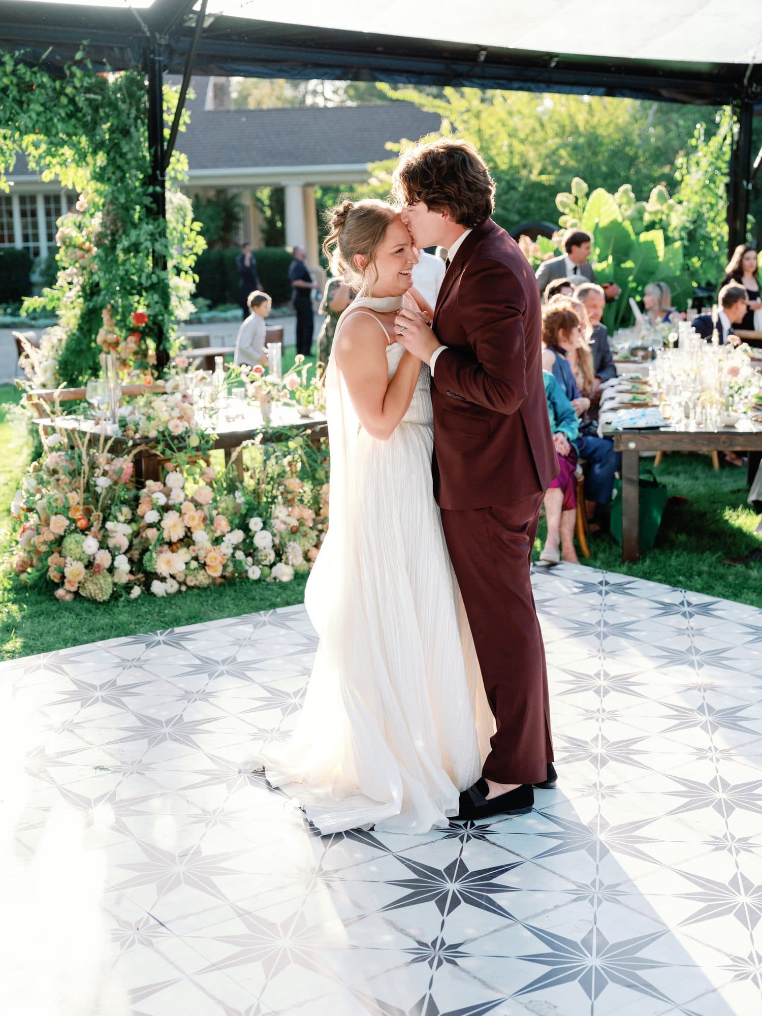 Jake kissing Lauren’s forehead during their first dance on a star-tiled dance floor