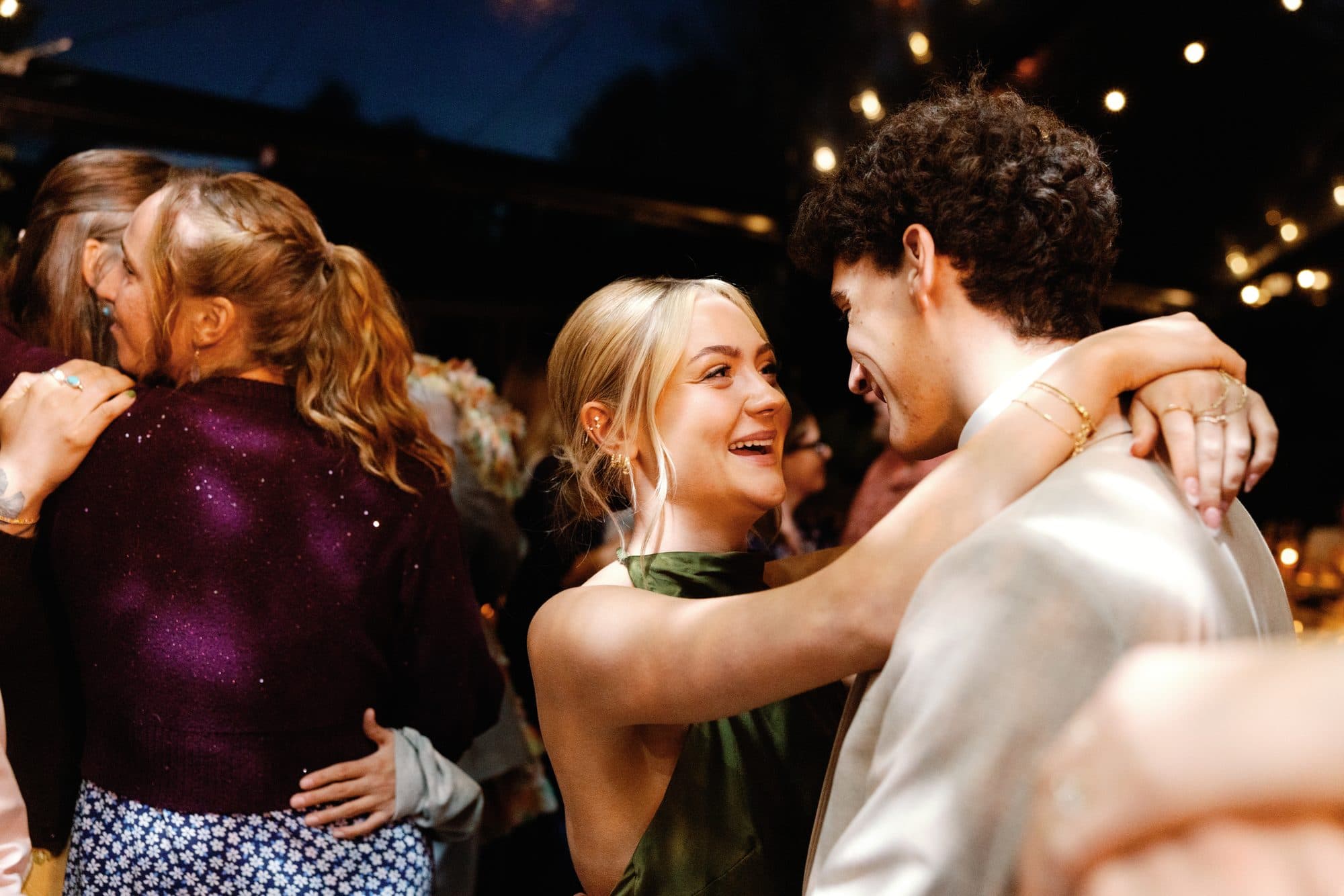 Friends laughing and holding each other on the dance floor