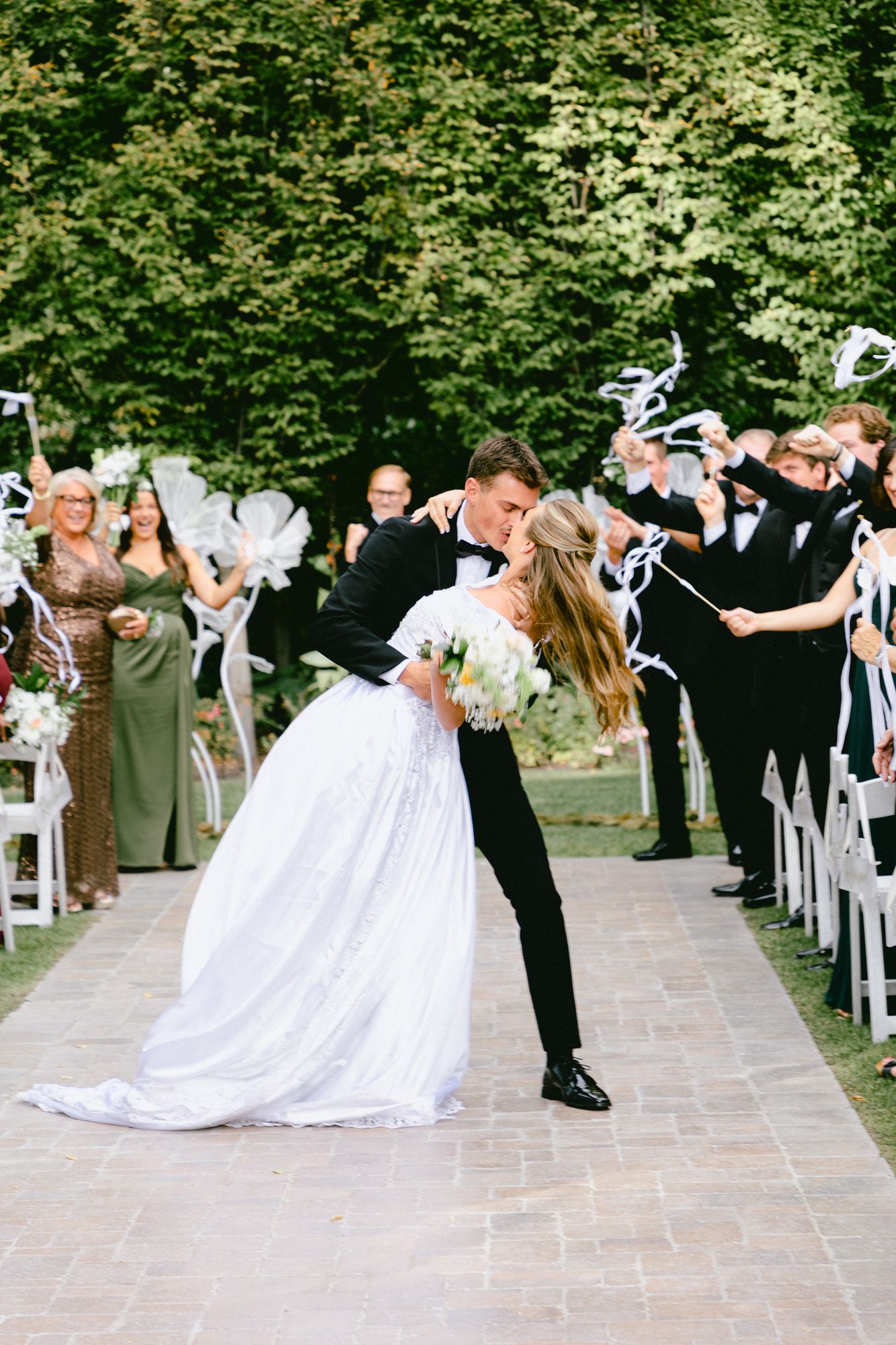 Kyle and Marita kissing on the way back up the aisle as their guests applaud