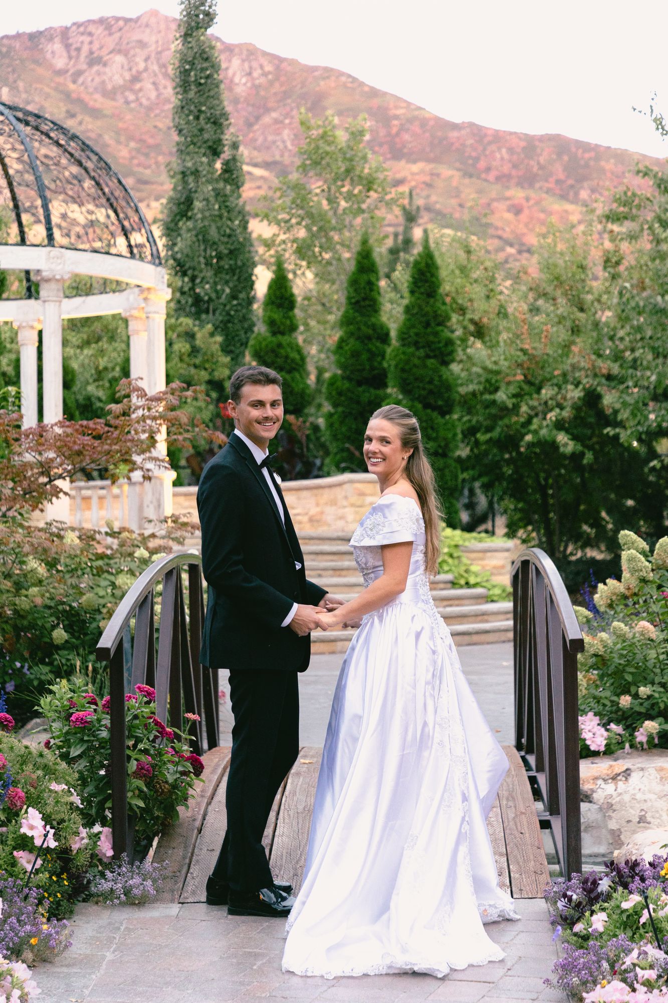 Kyle and Marita beneath a flowering arch at Bellissimo Gardens as the light drops